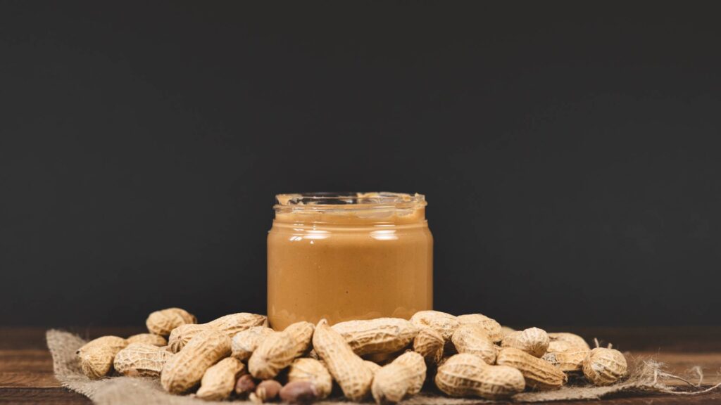 peanut butter jar with peanuts around on our blog about: What Is the Best Bait for Catching Mice?