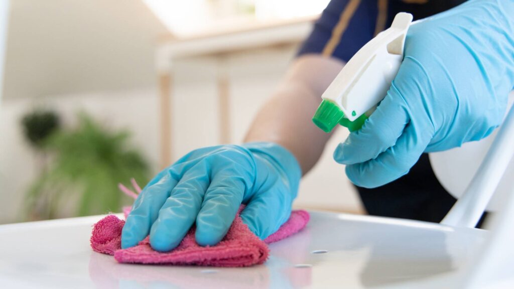 a person cleaning a table after a pest control treatment for roaches extermination