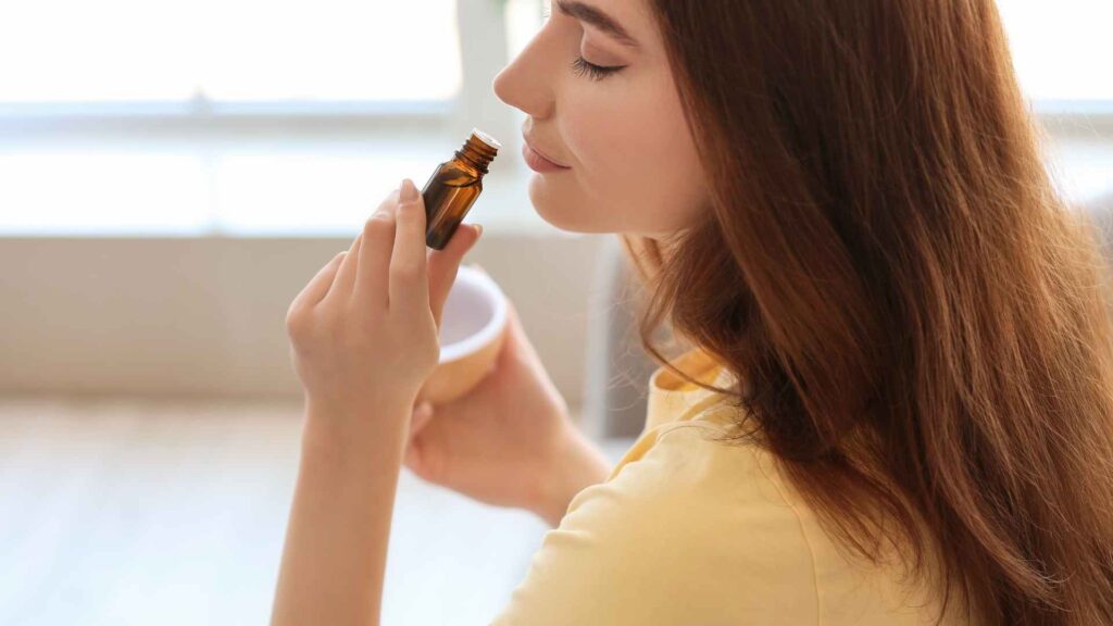 woman smelling essential oils to kill fleas in a carpet