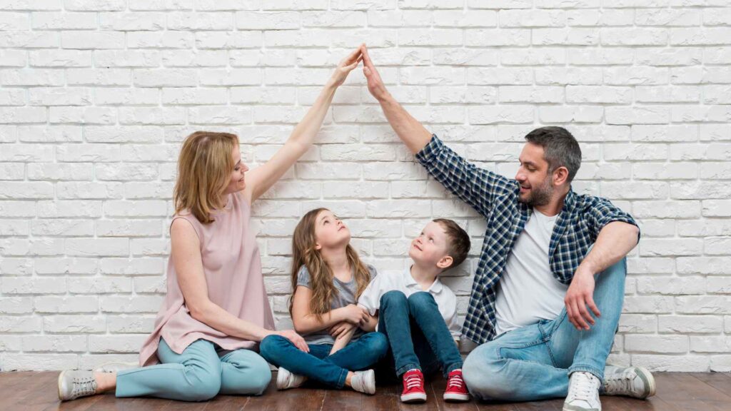 couple forming a house with their arms over their kids to represent your home your sactuary for old house borer treatment