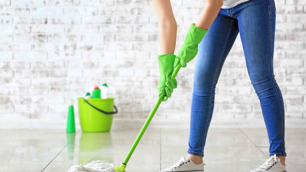 woman mopping the floor following How Do Fleas Get in the House Without Pets