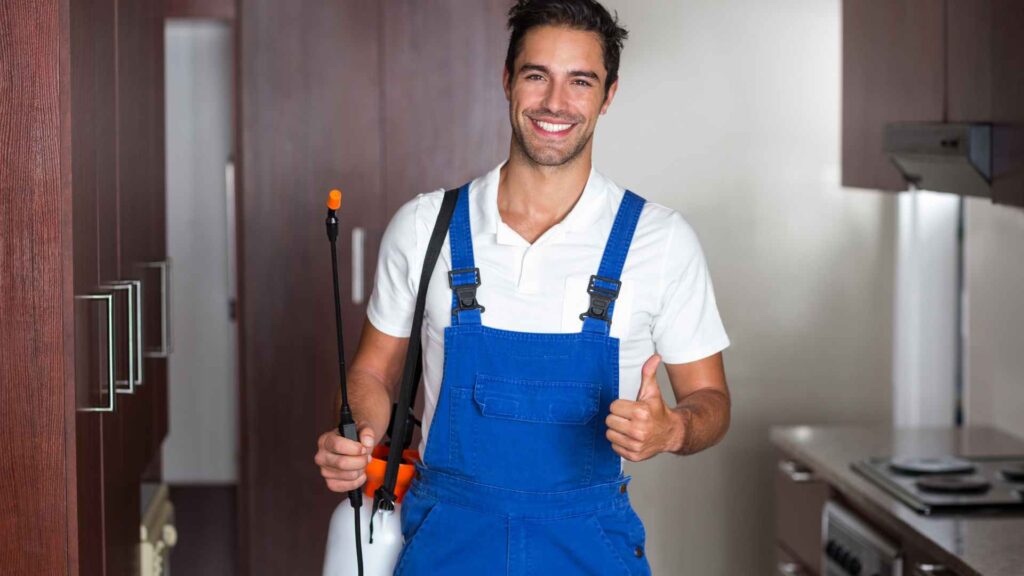 Man doing pest control in kitchen to represent professional treating moths in house