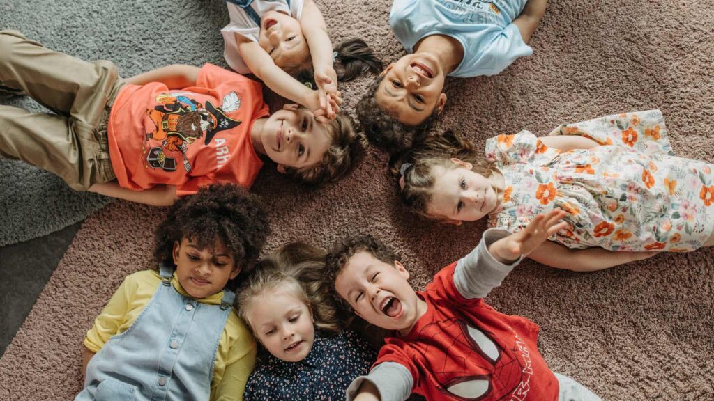 happy kids on a carpet to represent additional tips for preventing fleas with natural flea repellent for carpets