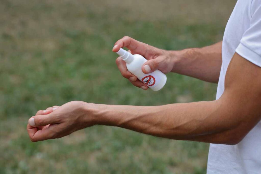 guy showing how to apply mosquito spray for backyards