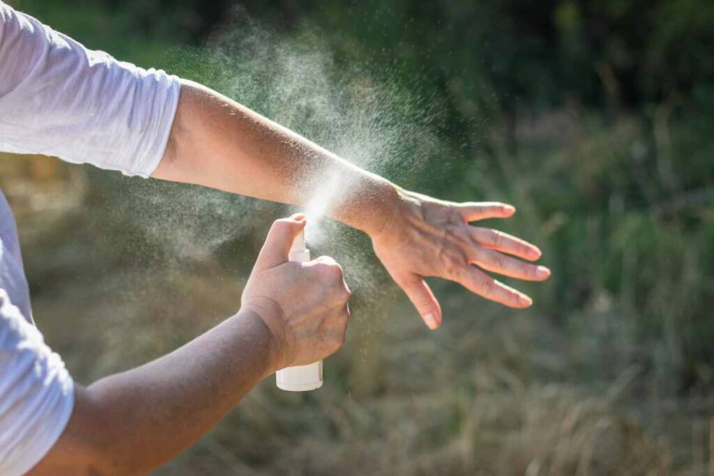 person applying mosquito spray for backyards using one of the most popular brands