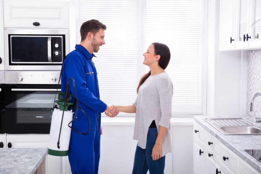 professional pest control technician talking with a customer to represent when to call a professional for a mosquito infestation in house