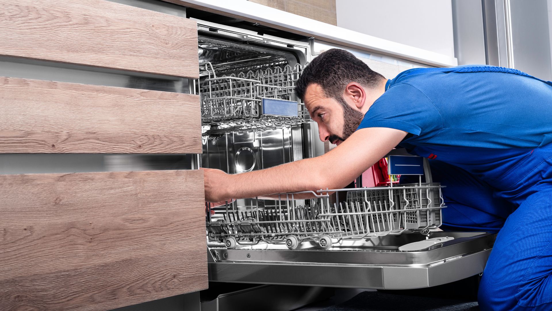 technician checking if mice caused damage to the dishwasher or under it