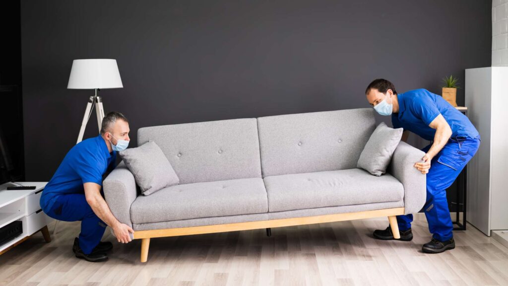 2 workers replacing a couch due to mice living on it 